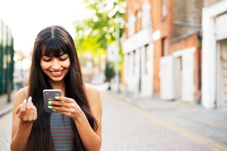 Woman using smart phone on street