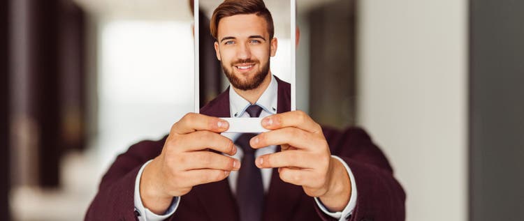 Smiling businessman showing photo on tablet
