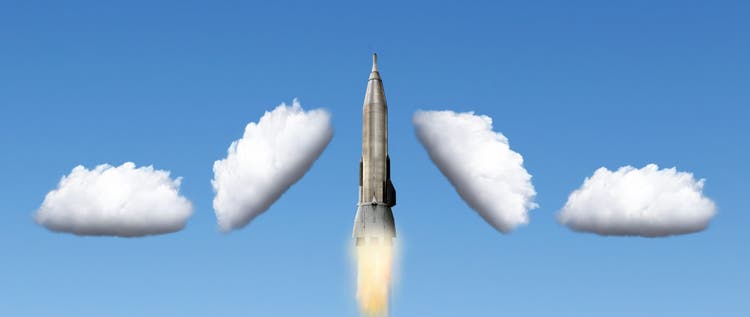 A rocket blasting off breaks through the clouds.