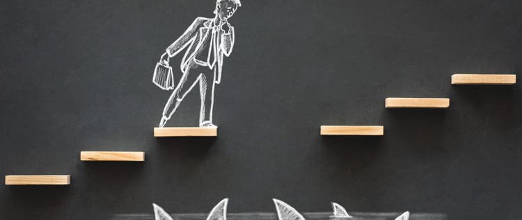Hand-drawn chalk picture of an executive on steps over sharks with one step missing