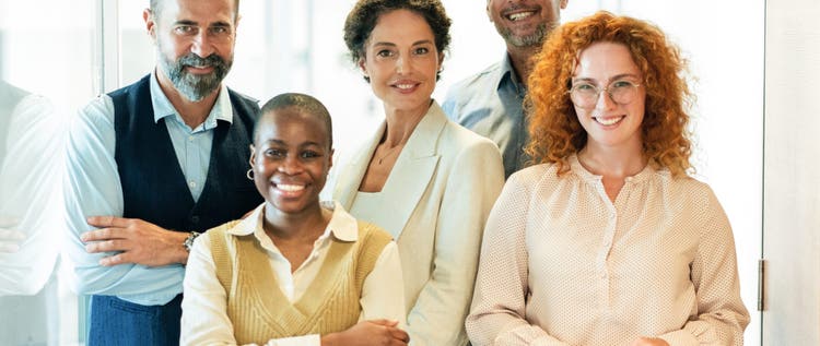 Business team standing together looking at camera and smiling in modern office. Modern multi ethnic team, creative occupation. Coworker teamwork concept.