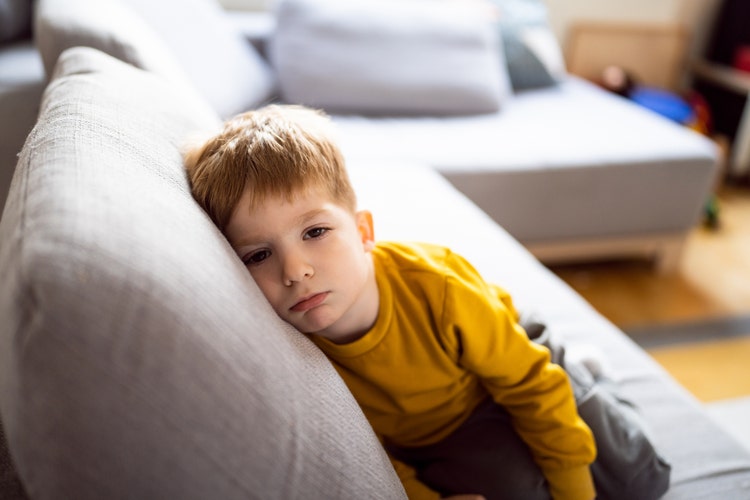 Portrait of displeased little boy at his home.