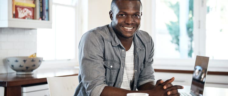 Cropped shot of a handsome young man using his laptop at home