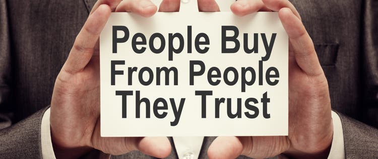 People Buy From People They Trust. Businessman holding a card with a message text written on it