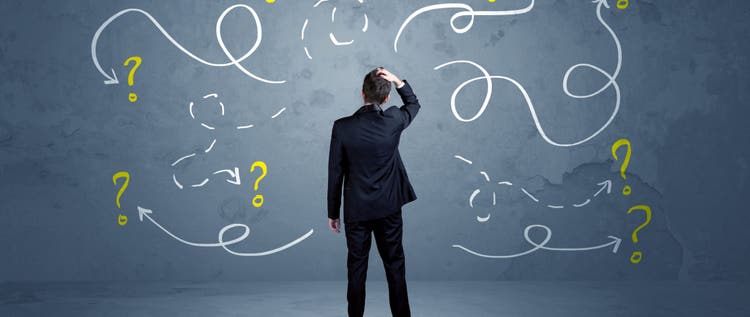 A salesman in doubt can not find the solution to the problem concept with curvy lined arrows and question marks drawn on urban wall