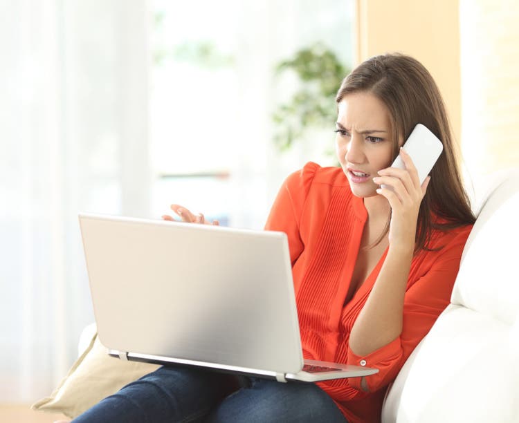 Angry woman calling to customer service with a laptop failure