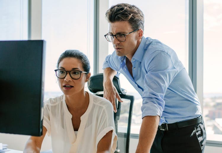 professional man and woman looking at a computer monitor