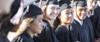 Multi-ethnic teenage graduates in cap and gown