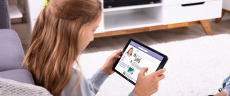 Girl Using Social Networking Site On Digital Table