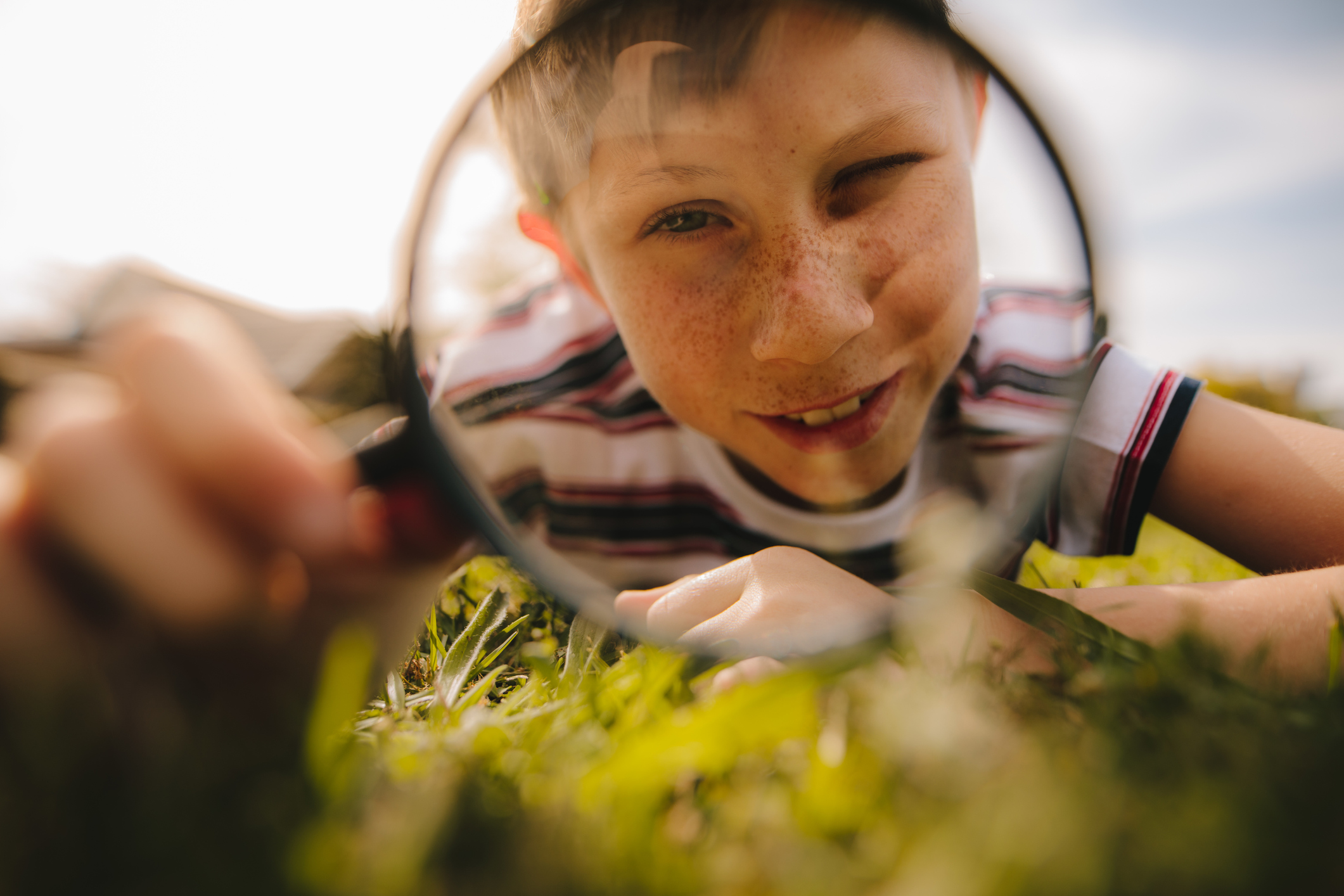 Boy looking through magnifying glass. cute boy exploring with magnifying glass.