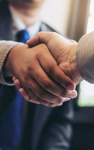 Two business men shaking hands during a meeting to sign agreement and become a business partner, enterprises, companies, confident, success dealing, contract between their firms.