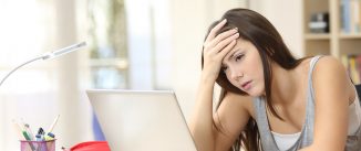 Worried and sad student female searching information in a laptop on line in a desk at home room