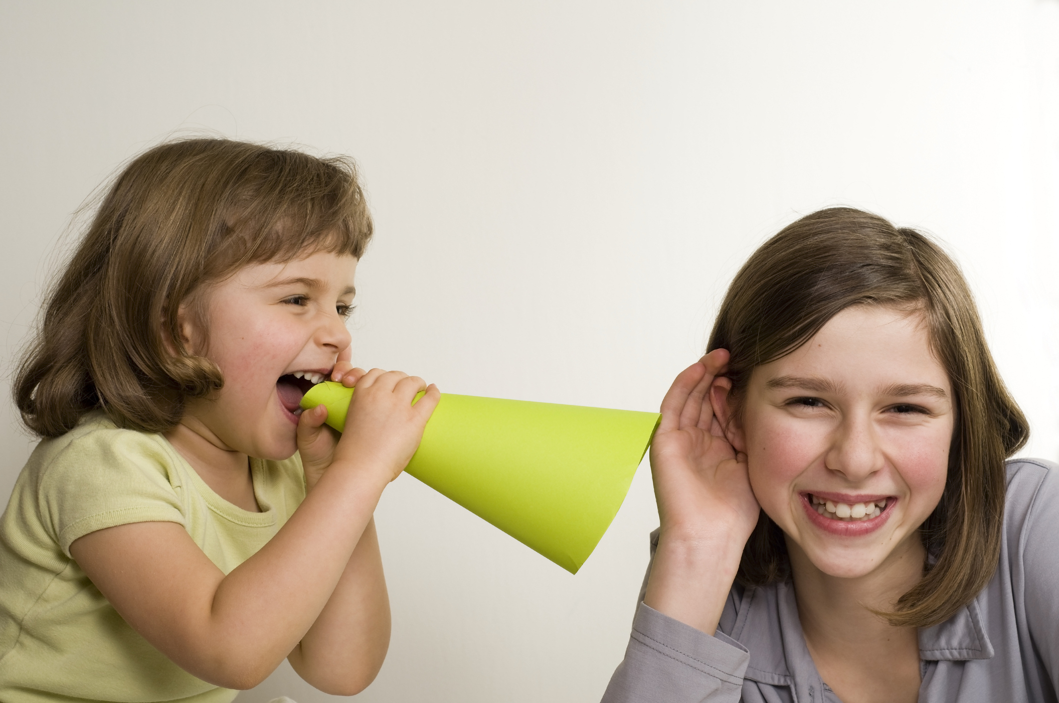 Girl shouting into a megaphone while another girl listens