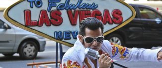 An Elvis impersonator in front of a Las Vegas sign