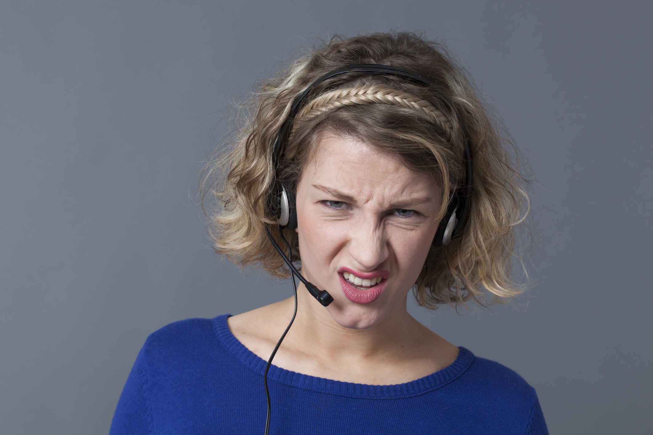 displeased young female professional working for a call center answering with a headset