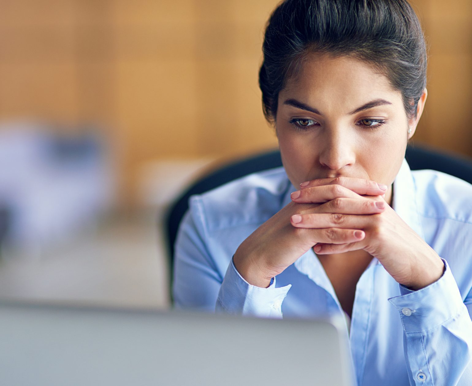 worried woman looks at computer screen