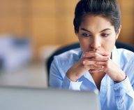 worried woman looks at computer screen