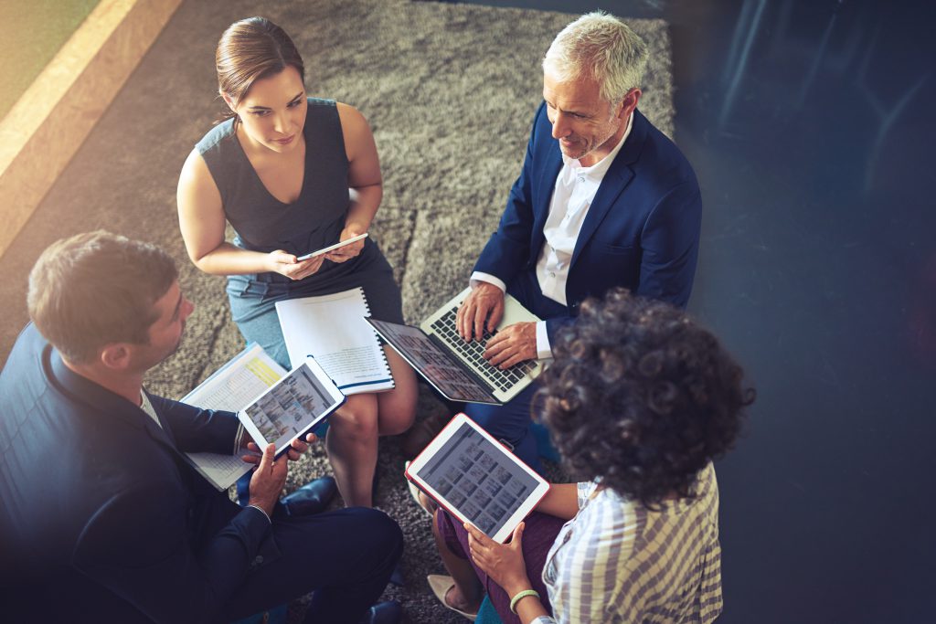 High angle shot of a group of businesspeople using their digital tablets