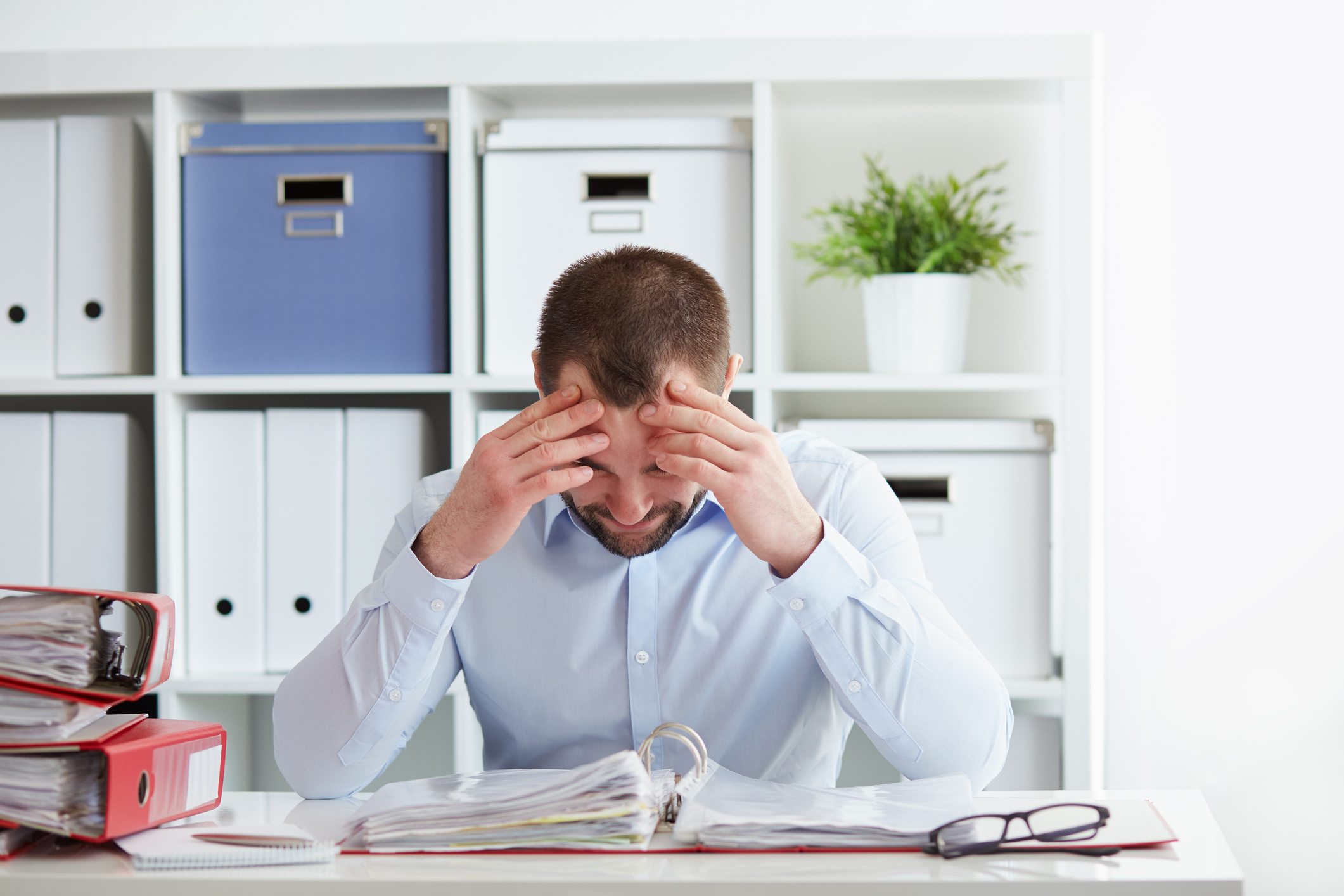 Young business man under stress with headache and migraine