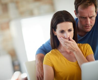 Cropped shot of a mature couple looking shocked while using a laptop together at home