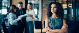 Beautiful African-american ethnicity woman sitting confidently in office looking away