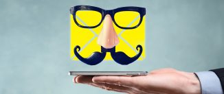 A yellow email icon with a false mustache and glasses floating over a cellphone resting on an open hand