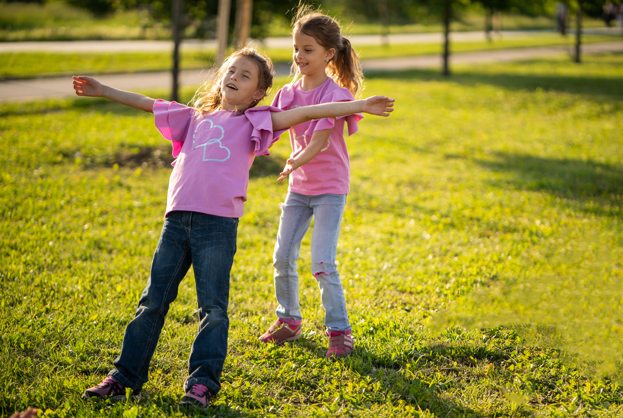 Cute girl with eyes closed falling down in sisters hands