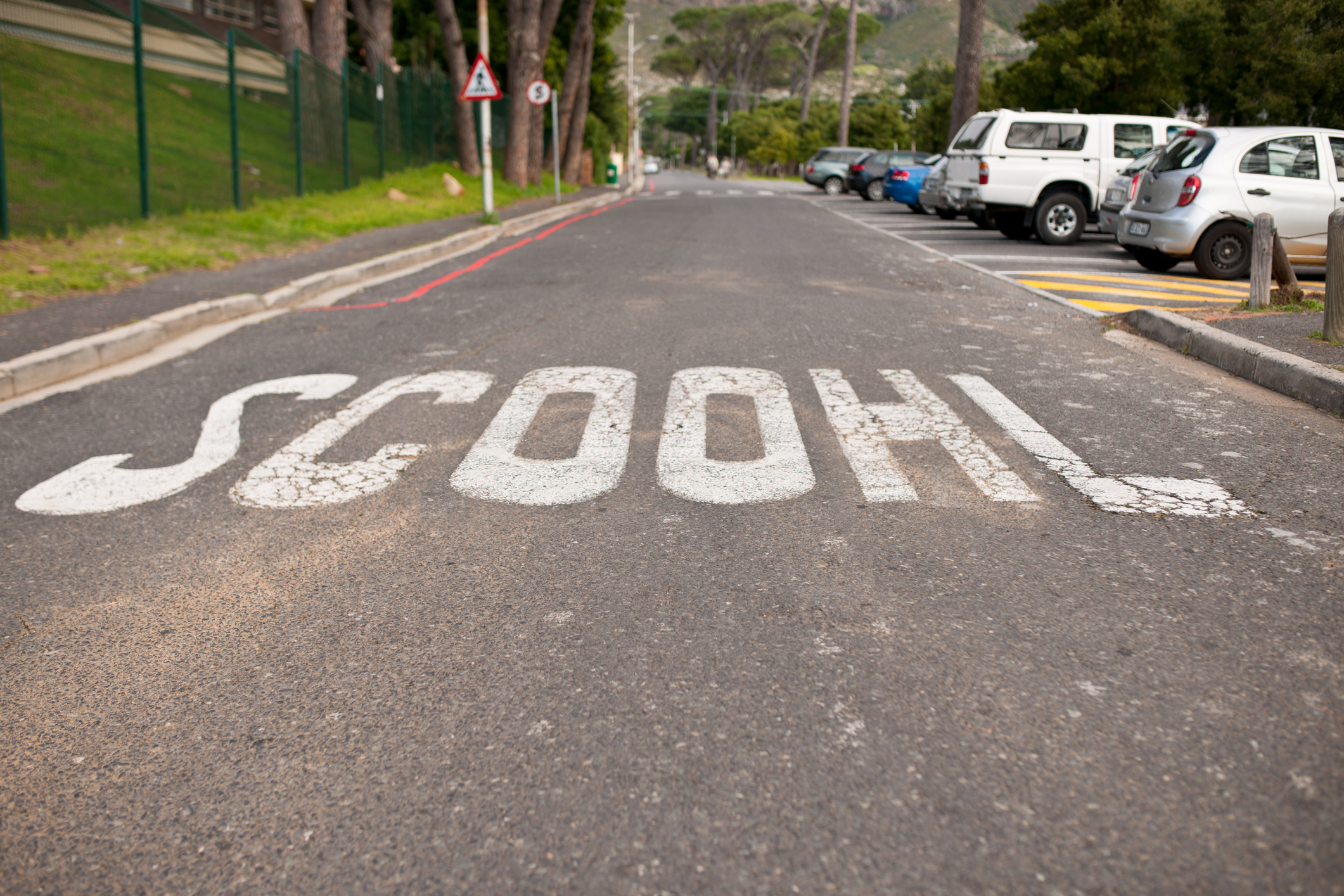 Shot of a school crossing on the pavement that spells school wrong