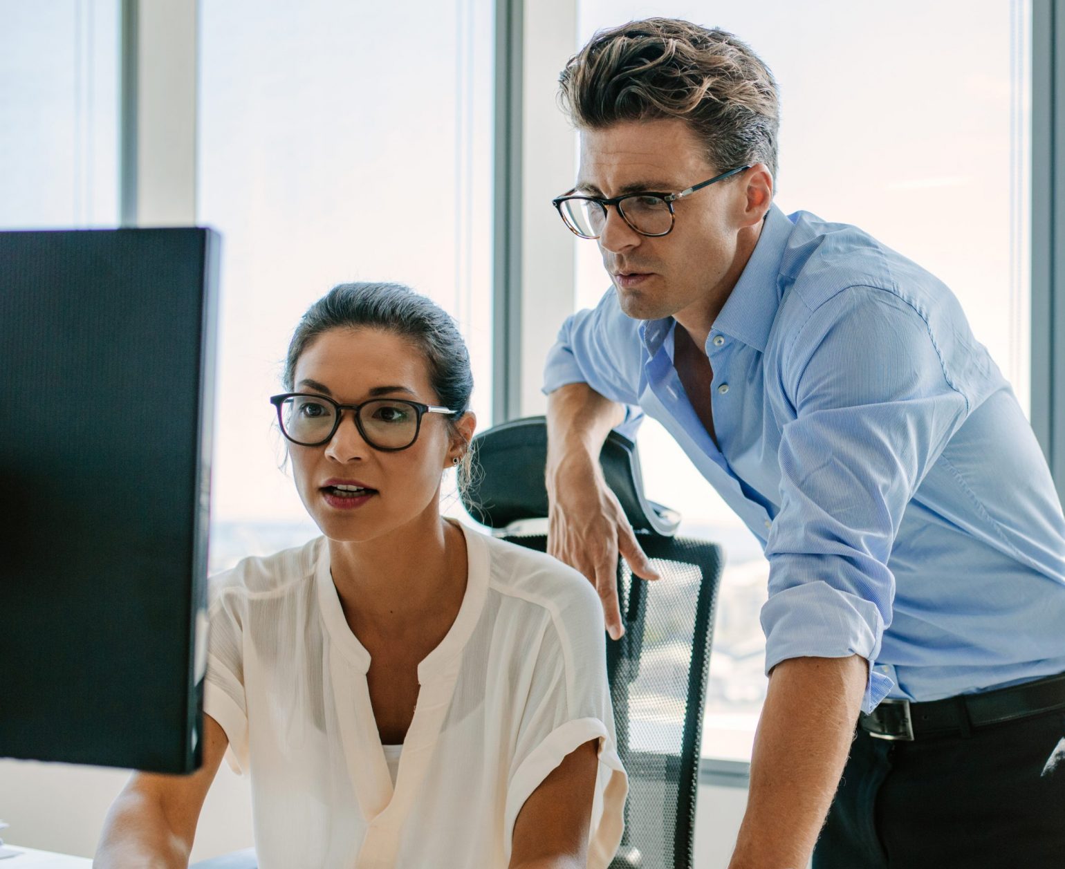 professional man and woman looking at a computer monitor