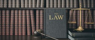 Law bookshelf with wooden judge's gavel and golden scale