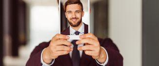 Smiling businessman showing photo on tablet