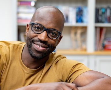Portrait of a happy African American man at home and looking at the camera smiling - domestic life concepts