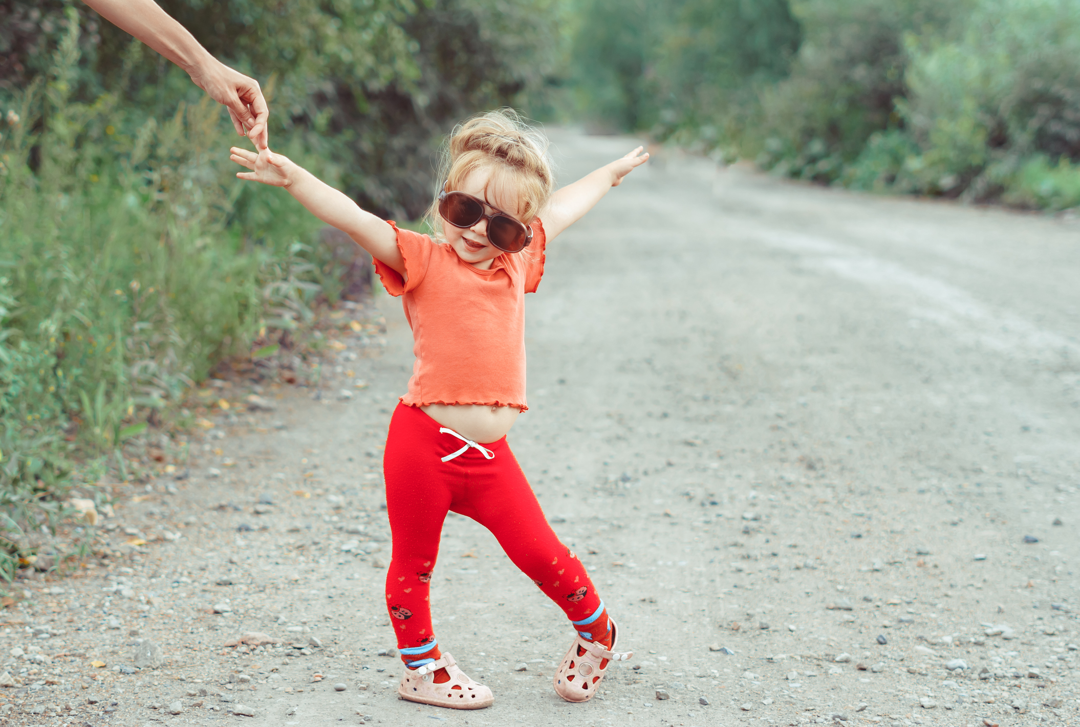 little girl dancing in glasses outdoors