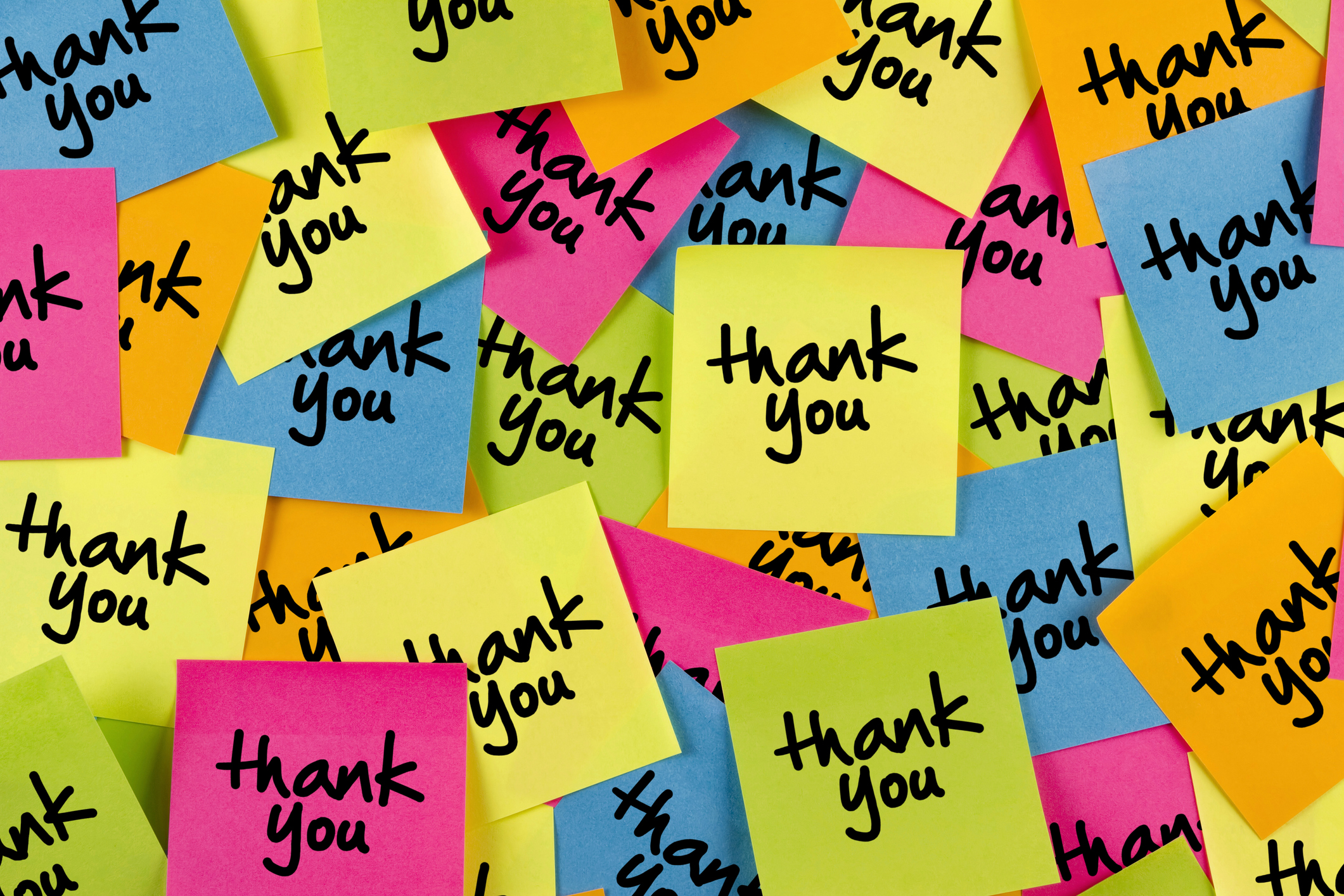 Thank you sticky note with multiple colored adhesive notes on bulletin board