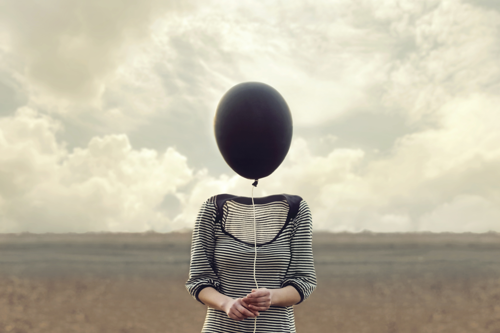 woman's head replaced by a black balloon