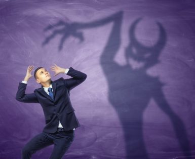 Shadow of devil trying to catch the frightened businessman.