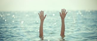 unrecognizable man hands waving for help, drowning into the sea.sunlight.horizontal shot.