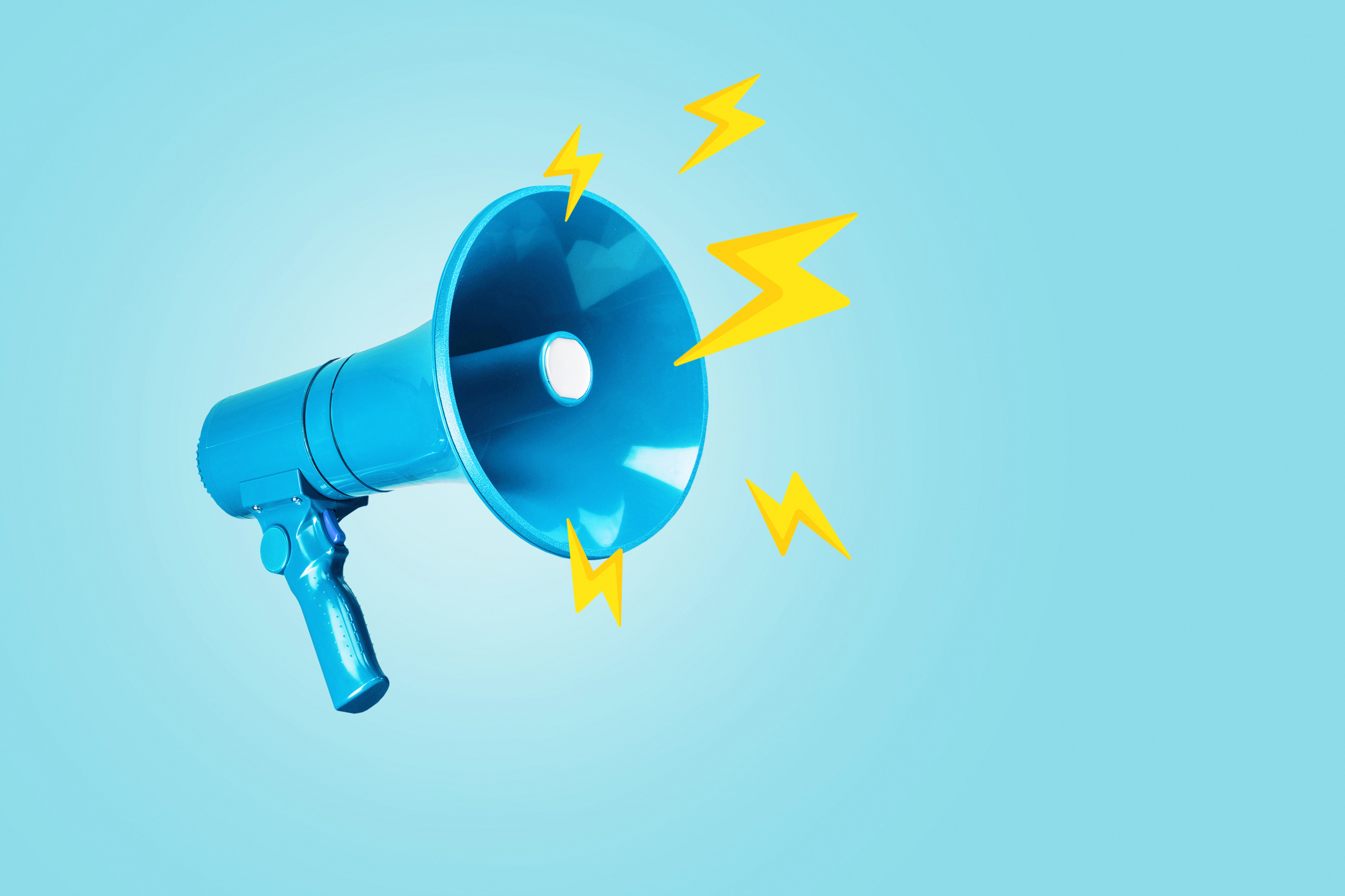 Creative blue loudspeaker with yellow lightning bolts on a blue background. Creative idea, attention! Urgent news. Lightning traffic, advertising and message.