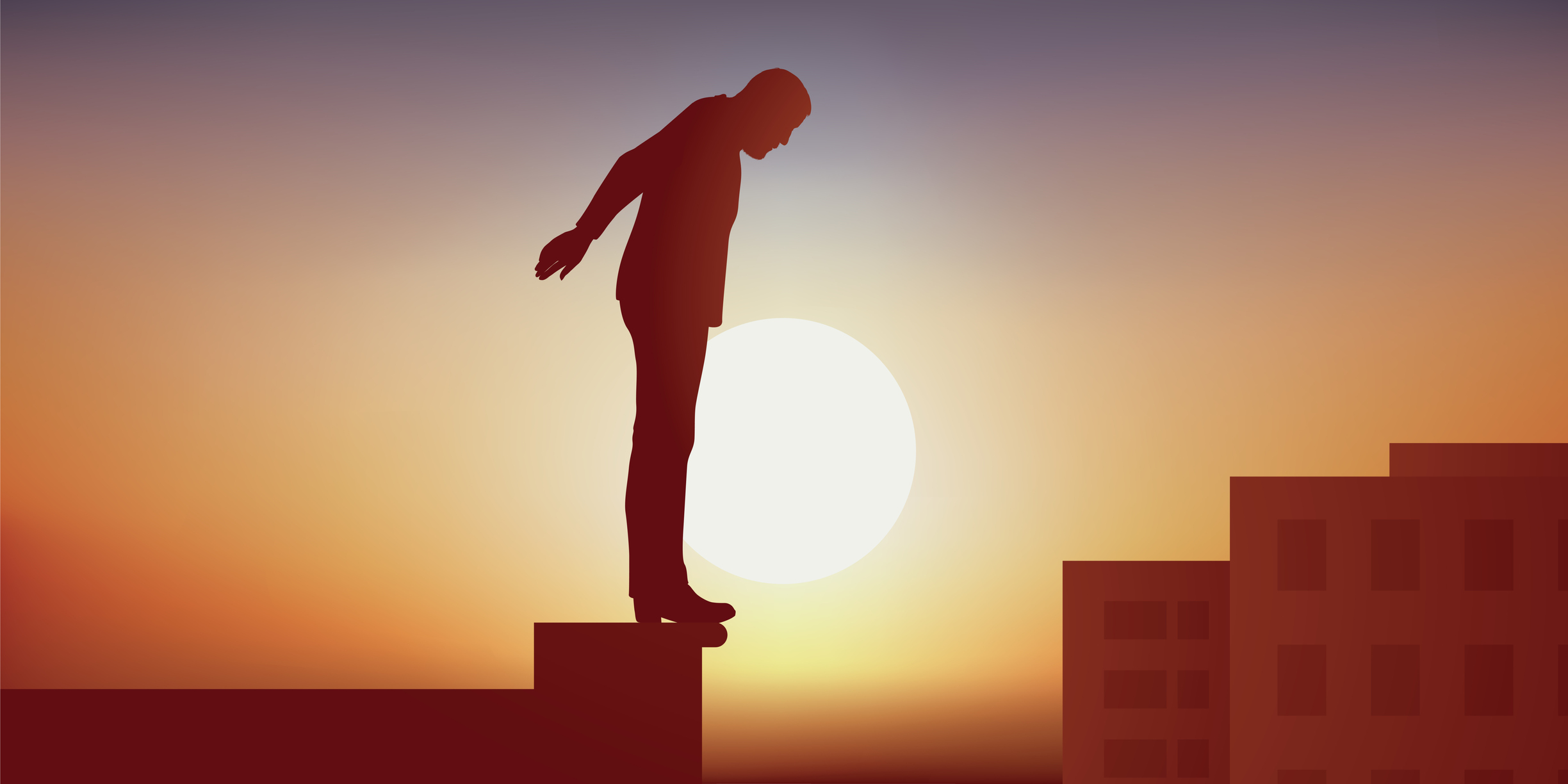 A man standing on the edge of a building roof, looking down.