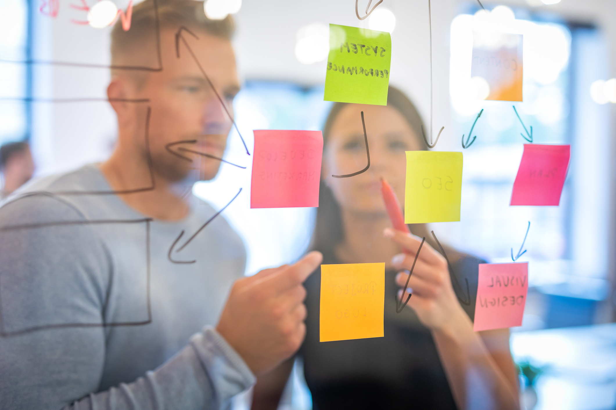 Business people meeting at office and use post it notes to share idea. Brainstorming concept. Sticky note on glass wall.