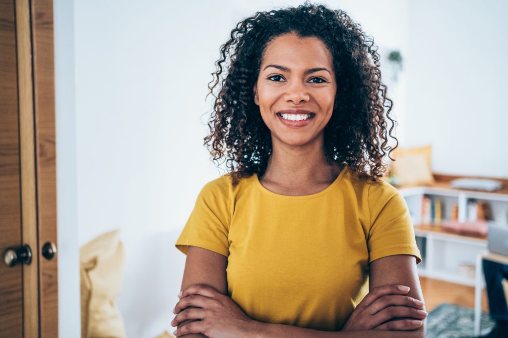 Shot of beautiful african-american businesswoman standing with crossed arms and looking at camera.