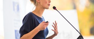 Pretty, young business woman giving a presentation in a conference/meeting setting (shallow DOF; color toned image)