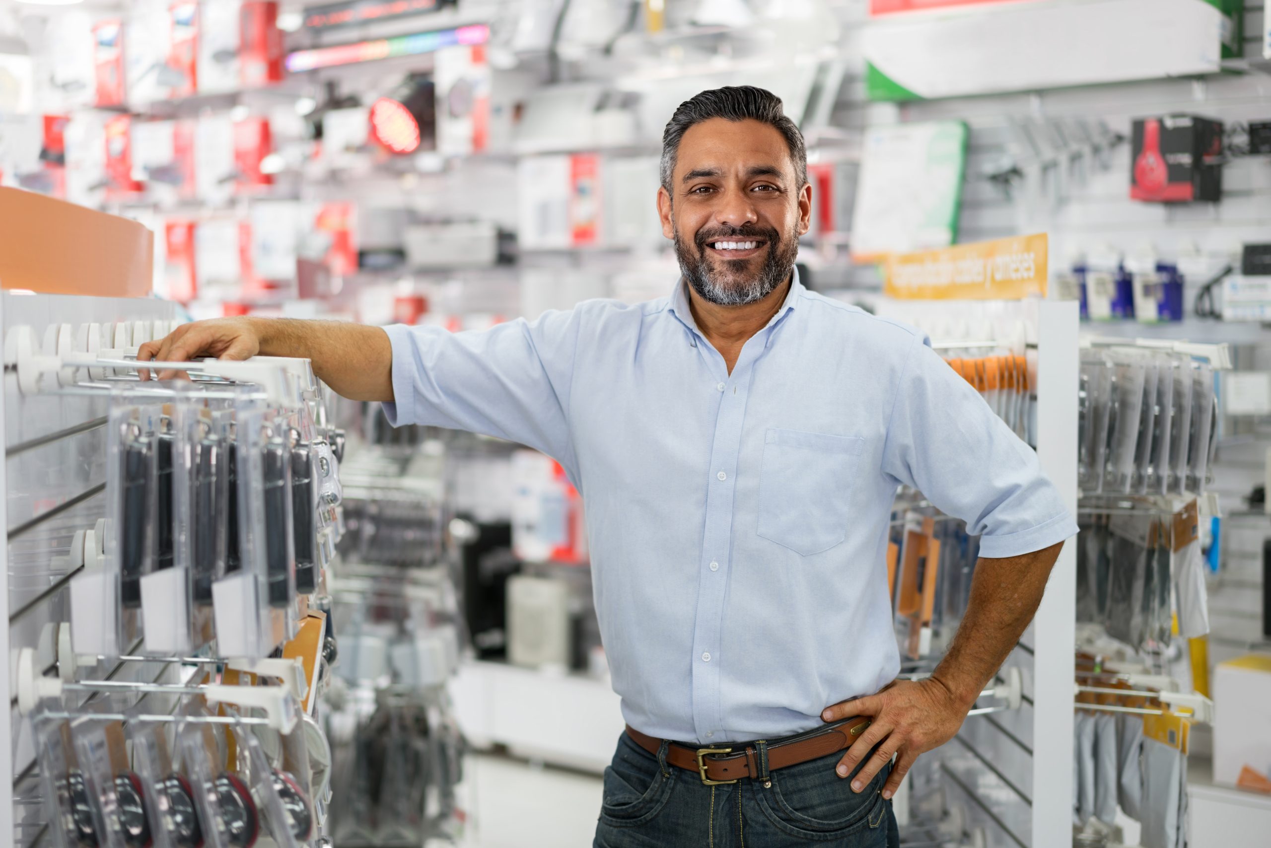 Happy business manager running a tech store and looking at the camera smiling
