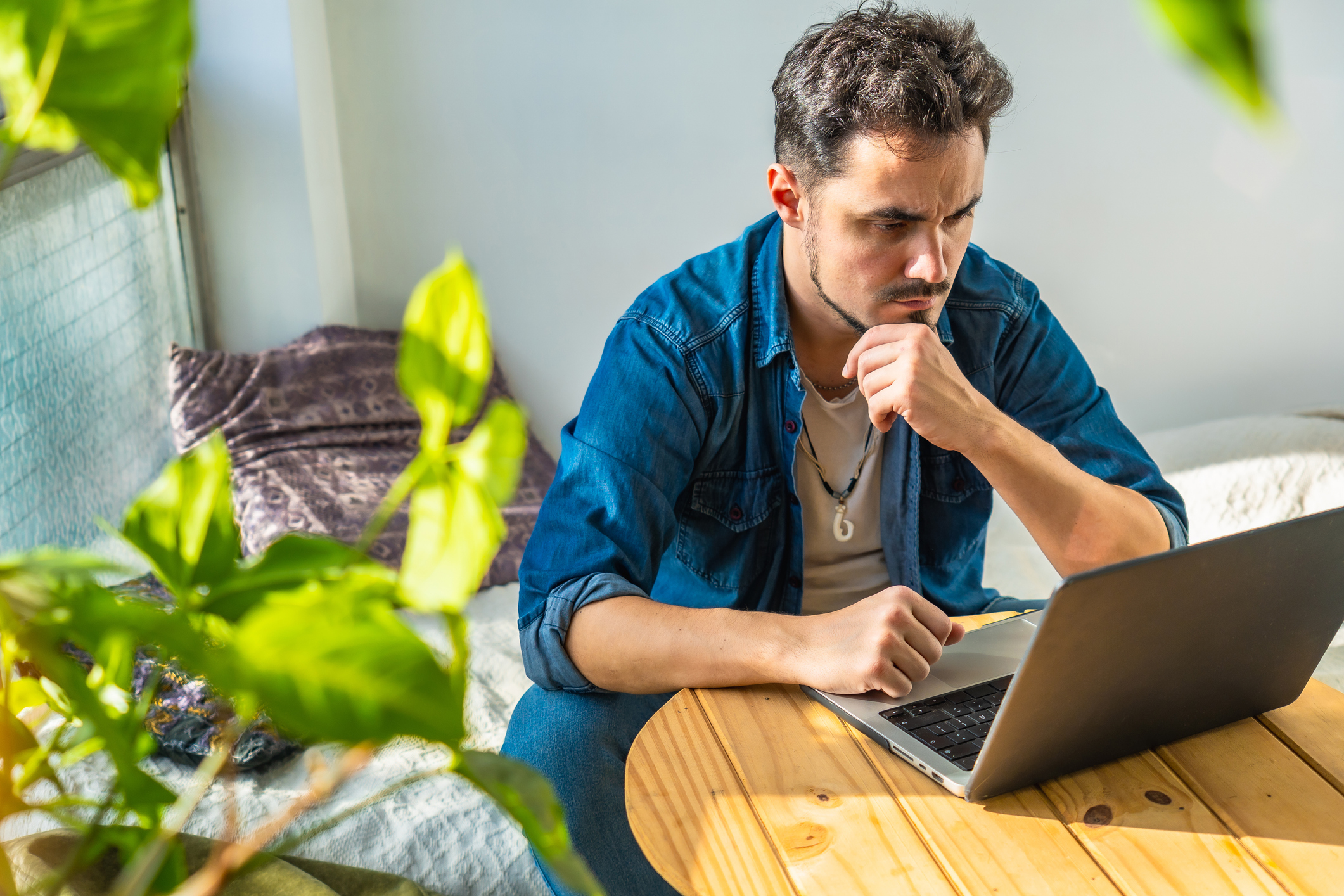 Concentrated young hispanic man working with laptop from home
