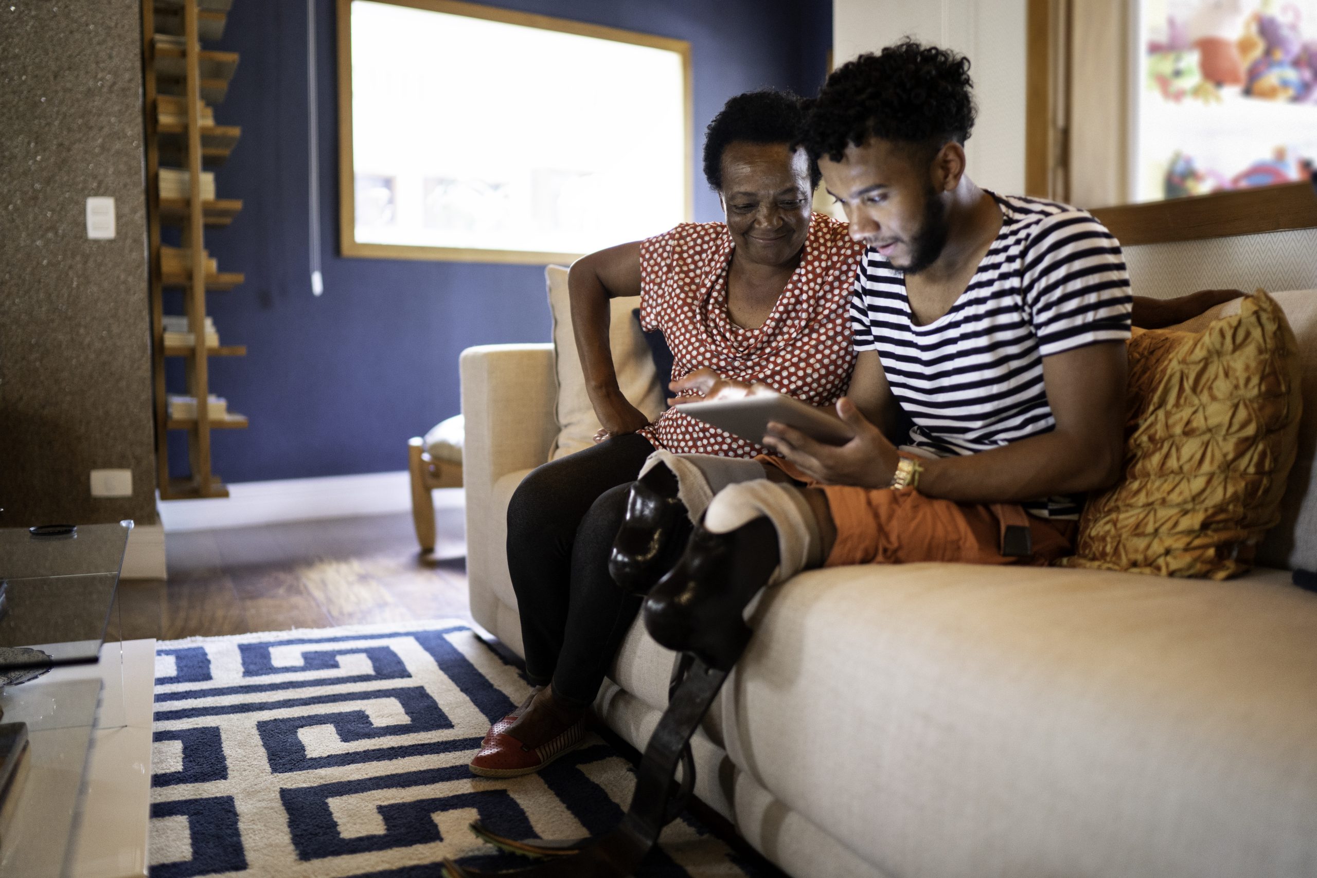 Son/Grandson using digital tablet with his mother/grandmother